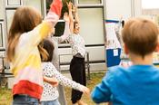 Lehman leitet Bewegungen für einen Kinder-Workshop an.